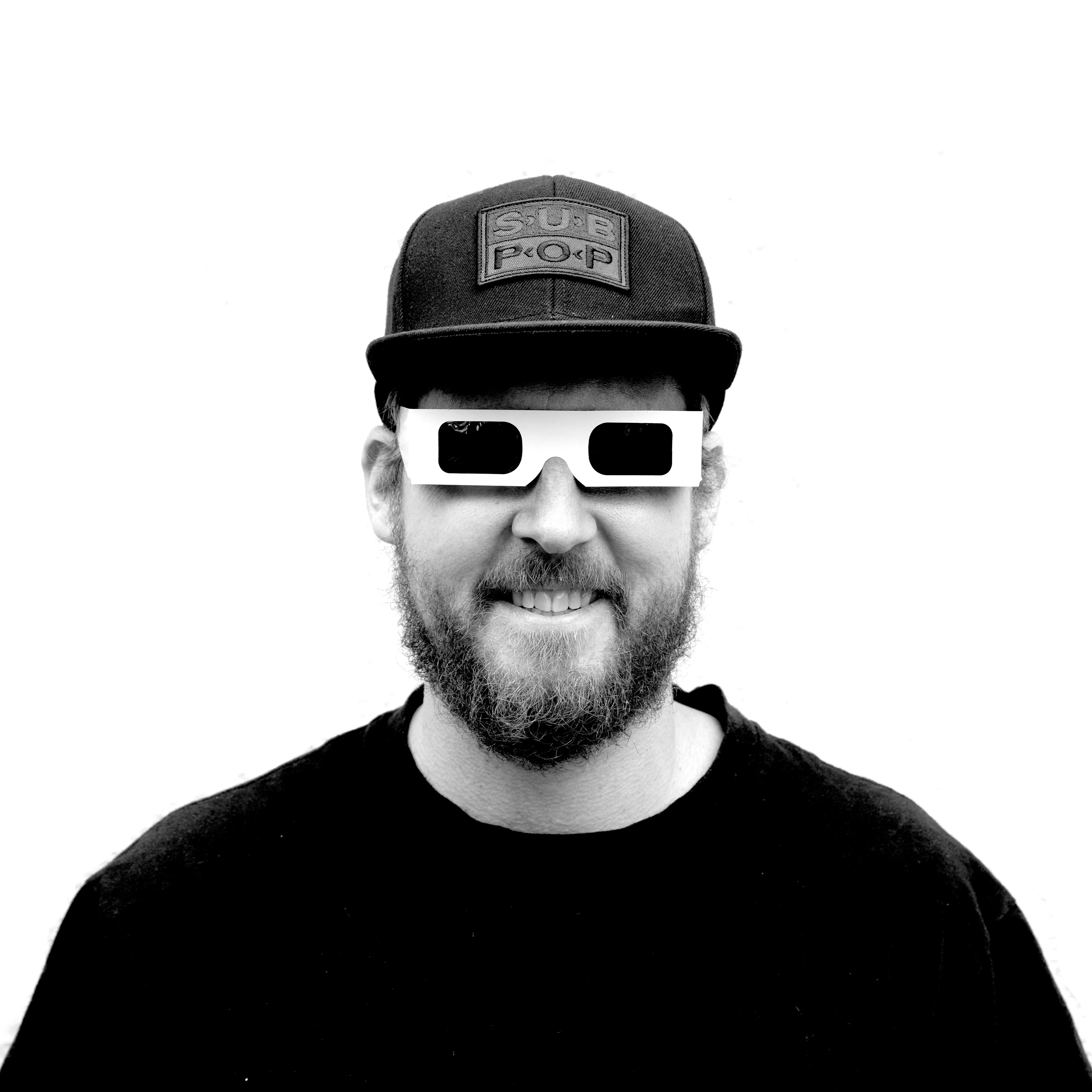 Coldie, wearing red/cyan 3D glasses and a Sub Pop cap — black-and-white portrait.