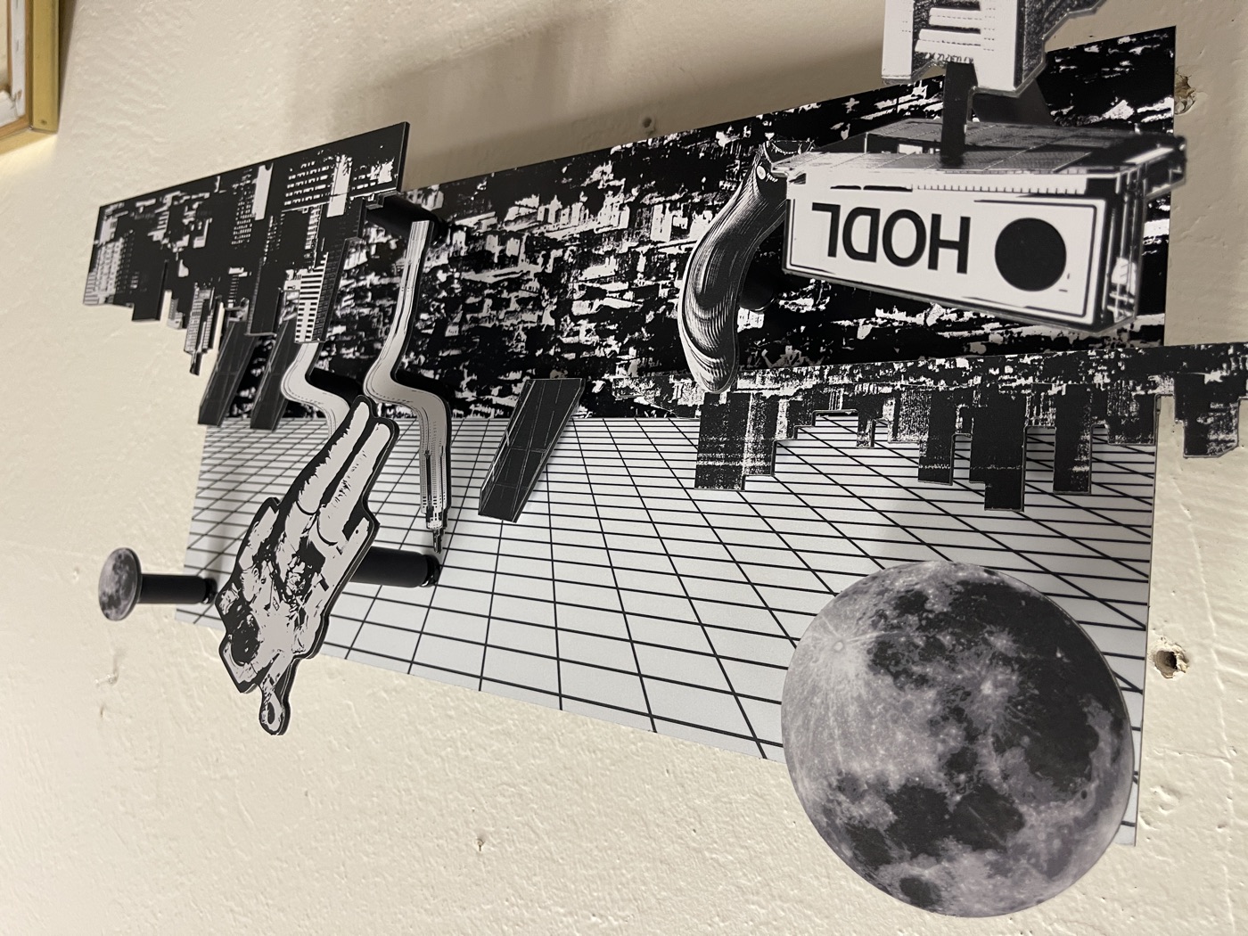 Layout: a large moon over a grid ceiling, the HODL billboard pushed far forward at bottom left and the astronaut raised on a long spacer at right